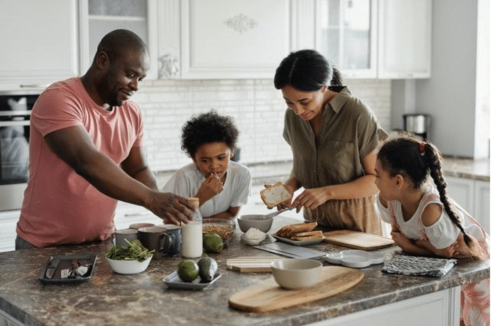 Family of four prepares food in their home kitchen