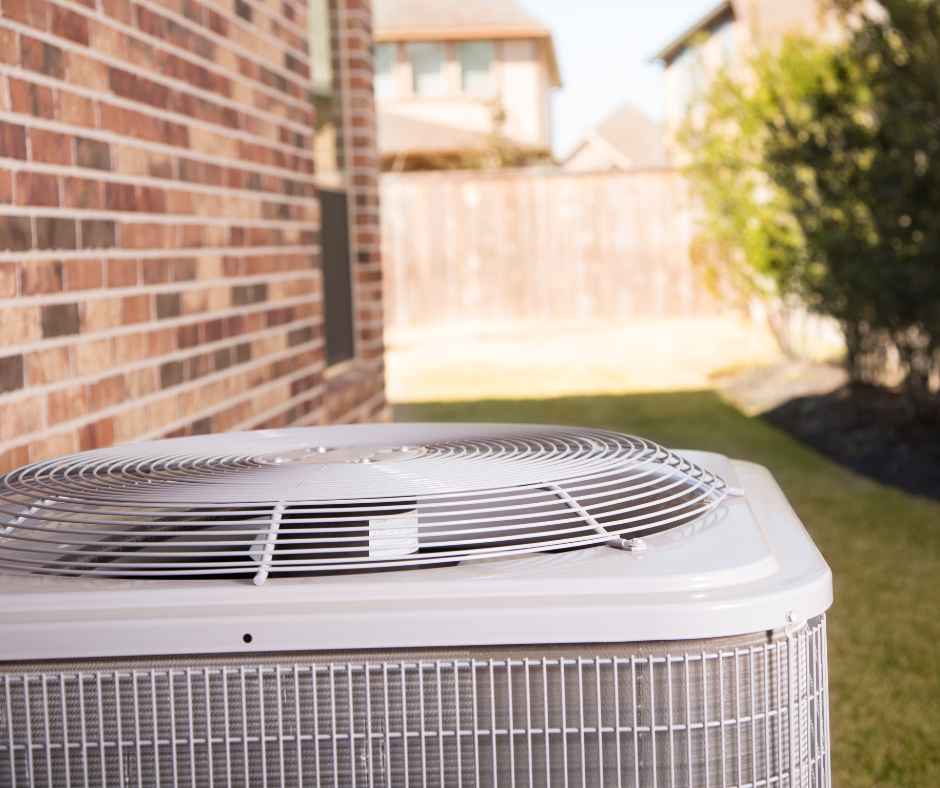 An HVAC unit outside the wall of a home in the suburbs